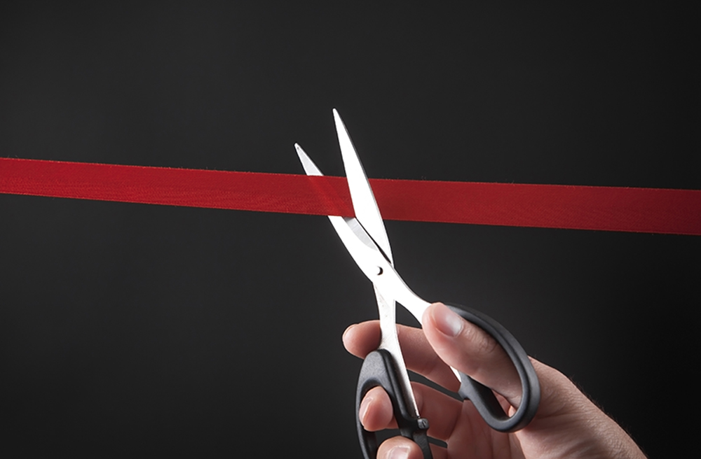 scissors cutting red tape